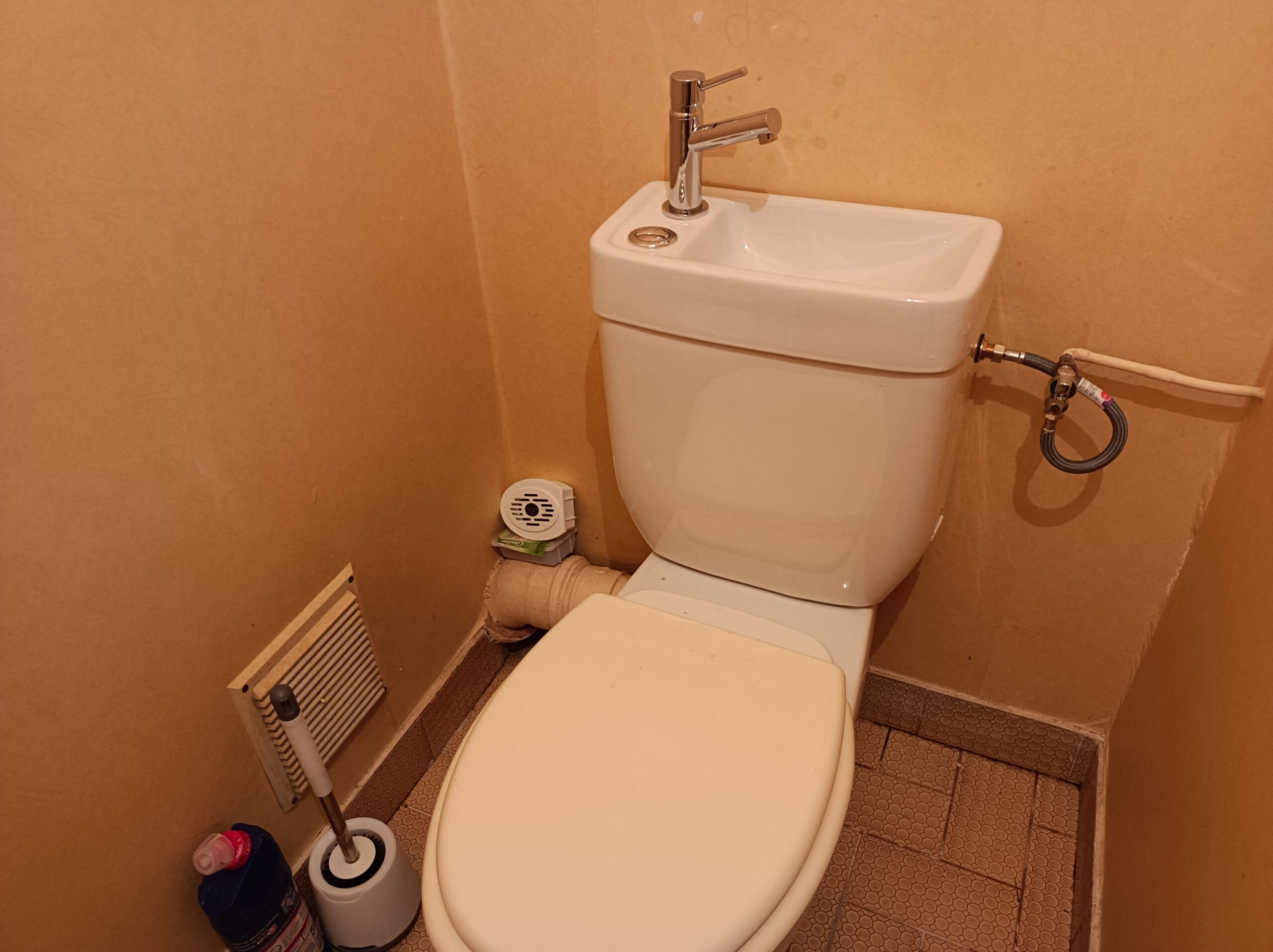 Pose d'un réservoir de toilettes lave mains